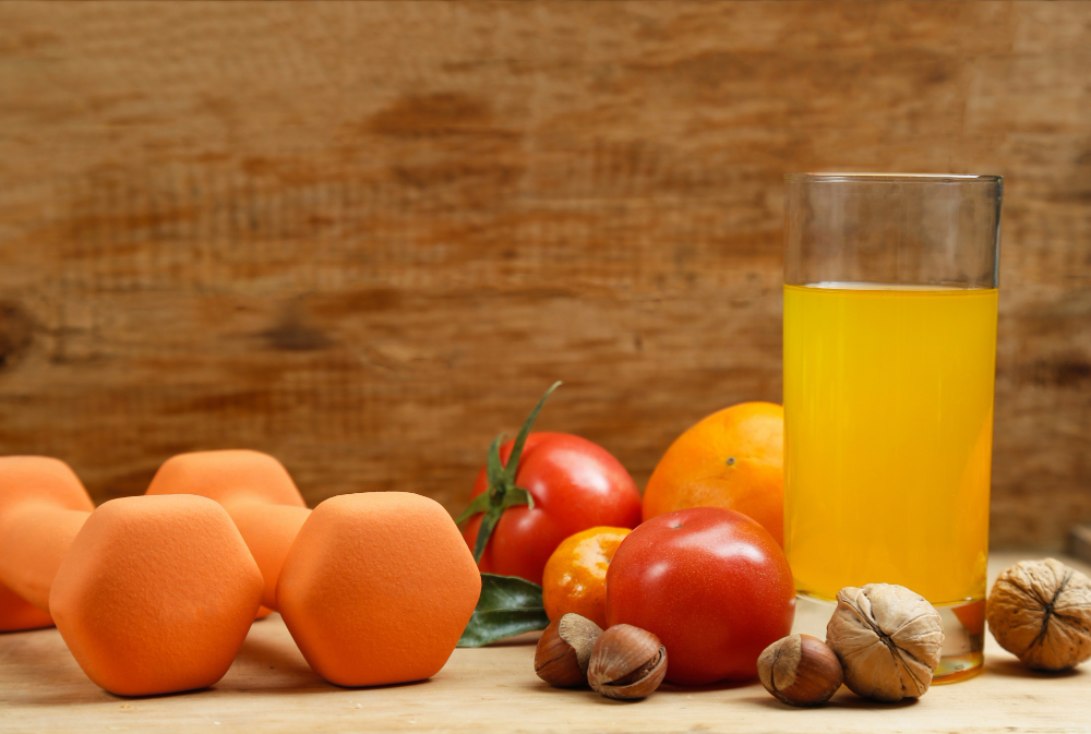 dumbbell orange juice fruit nuts wooden table sport health lifestyle concept